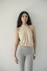 Top halter color beige con lentejuelas, escote halter y espalda descubierta con lazo regulable.