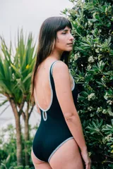 Traje de baño entero negro de lycra texturizada con bordes de terciopelo celeste.