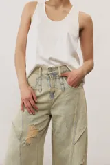 Pantalón de jean de corte wide leg, tiro medio y lavado claro con efecto desgastado. Presenta diseño de múltiples paneles con costuras pespunteadas verticales y roturas en ambas piernas.