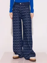 Pantalón de jean azul con estampado de besos en blanco, de corte ancho y tiro medio.