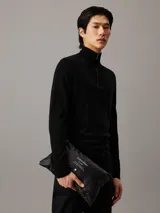 Chaleco negro acolchado Calvin Klein con cuello alto, cierre de cremallera, bolsillos laterales con cremallera, forro y aislante de plumas sintéticas.