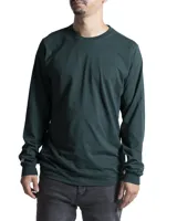 Remera de manga larga en color verde oscuro, con cuello redondo y puños acanalados. Presenta un diseño liso y minimalista con un pequeño detalle de etiqueta en el puño derecho.