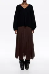 Falda midi de corte fluido con diseño acampanado y vuelo. Presenta una textura ligera y semitransparente con forro interior a tono.