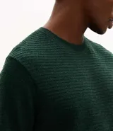 Remera de manga corta y cuello redondo, confeccionada en tejido de tricolina con textura acanalada. Presenta un diseño de corte clásico y ajuste cómodo.