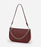 Cartera tipo baguette color bordó, confeccionada en poliuretano con acabado liso. Presenta una cadena decorativa plateada en el frente, cierre superior con cremallera y correa larga ajustable y desmontable.