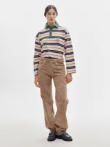 Pantalón de pana roja con corte holgado y tiro medio. Presenta una línea dorada a lo largo de la pierna.