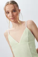 Top verde con textura de panal, breteles finos blancos y escote en V.