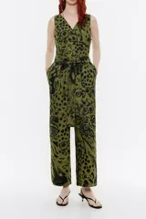 Mono de lino color verde con estampado animal print en negro, de corte recto y largo tobillero, con escote en V, manga sisa, cierre con cremallera trasera invisible y cinturón de tela.