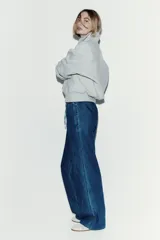 Pantalón denim de corte holgado en mezcla de lyocell y algodón, color azul. Presenta tiro alto con cintura elástica revestida y cordón ajustable, bolsillos laterales discretos y piernas rectas.