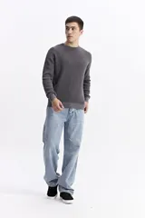 Sweater de hombre con textura waffle, color verde oliva desgastado (acid wash), cuello redondo y puños y ruedo acanalados. Presenta un pequeño logo bordado en el pecho.