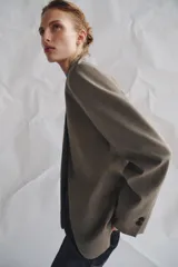 Blazer de cuello subido con cierre frontal cruzado de botones. Presenta manga larga con hombreras y puños con botones, bolsillos de vivo en el delantero y forro interior.
