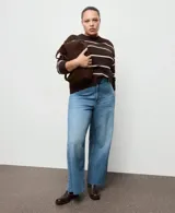 Jeans de denim azul de tiro medio, corte wide leg y diseño de pernera ancha con terminación deshilachada en el bajo.
