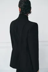 Blazer entallada color negro de ZARA Woman Collection, con escote en pico, manga larga con hombreras, bolsillos con solapa en el delantero y cierre frontal con botones ocultos.