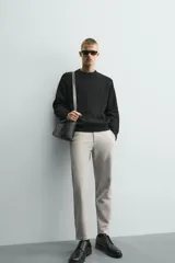 Pantalón chino de corte slim fit, confeccionado en tejido elástico. Presenta bolsillos frontales, bolsillos traseros de vivo con botón y cierre frontal con cremallera y botón.