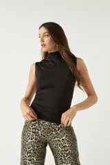 Top sin mangas de cuello alto, confeccionado en tejido suave y elástico que se ajusta al cuerpo.