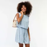 Short de tela ligera con estampado de vichy en color celeste y blanco, con cintura elastizada.