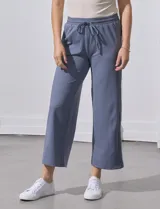 Pantalón jogger color crema, de corte ancho, con pretina elastizada y lazo de ajuste.