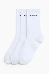 Pack de tres pares de medias deportivas blancas de caña media, confeccionadas en punto acanalado con tecnología DryMove. Presentan el texto "MOVE" bordado en negro en la parte superior y secciones de ventilación en malla.