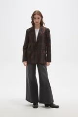 Blazer de corte holgado con diseño a cuadros en tonos marrones y negros. Presenta cuello con solapa, cierre frontal con un botón y bolsillos laterales con solapa.