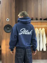 Hoodie azul marino de corte holgado con capucha amplia y estampado en la espalda con la palabra 'Ittab' en tipografía cursiva blanca.