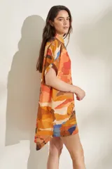 Vestido corto de lino blanco con estampado artístico de paisaje costero, cuello mao y mangas cortas holgadas.