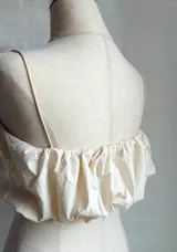 Top corto color crema con breteles finos y fruncido en el busto.