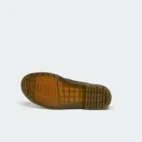 Bota de caña media Dr. Martens modelo 1460, confeccionada en cuero marrón con acabado mate. Presenta cierre de cordones con ocho ojales metálicos, costuras amarillas características en la unión de la suela y suela de goma acanalada con amortiguación de aire.