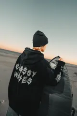 Canguro negro con capucha, bolsillo delantero y estampado de llamas en las mangas.