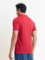 Remera tipo polo de color azul, con cuello clásico, cierre de botones y mangas cortas con terminación acanalada.