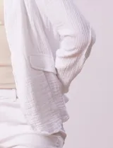 Chaqueta color crema de algodón con bolsillos simulados y terminación desflecada.