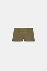 Shorts mini verde militar de tiro medio con aplicación de tiras horizontales y botones metálicos en el frente. Cuenta con cierre lateral de cremallera oculta.