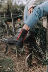 Botas de cuero color marrón chocolate con suela de goma tipo track en color negro. Presentan un diseño de caña media con cierre frontal metálico y costuras reforzadas.