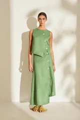 Falda midi verde de lino, con diseño asimétrico, tajito frontal y cierre lateral con botones de madera con ojales bordados.