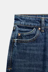 Pantalón jeans Z1975 de tiro alto y diseño mom fit, color azul claro con lavado desgastado, de corte tobillero y cinco bolsillos. Cierre frontal con cremallera y botón metálico.