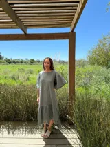 Vestido verde oliva de lino, corte suelto, con mangas abullonadas y volado en el ruedo.