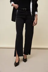 Jeans de corte straight y tiro medio, color negro, confeccionados en denim con spandex. Presenta un sutil tajo en la parte inferior del ruedo.