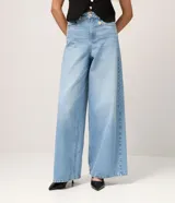 Pantalón de jean estilo pantalona con cintura alta, corte amplio desde el cuadril y cinco bolsillos funcionales. Presenta cierre frontal con botón y cremallera, además de un detalle de charm metálico en la cintura.