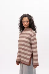 Buzo de tejido de punto con diseño de rayas horizontales en tonos marrón y beige, cuello alto y mangas largas con terminación acampanada.