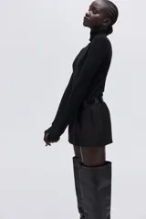 Top de manga larga confeccionado en punto fino, con diseño de corte ajustado y cuello alto.