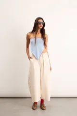 Pantalón de gabardina de algodón color marfil, de silueta tipo barrel con pinzas delanteras, tiro alto y diseño holgado con costuras decorativas.