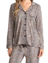 Conjunto de pijama de dos piezas con estampado animal print. La parte superior es una camisa de manga larga con cuello solapa, escote en V, cierre frontal con botones y bolsillo aplicado. El pantalón cuenta con cintura elástica y lazo de ajuste.