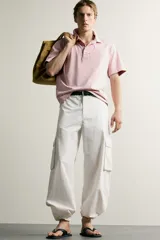Polo de corte regular fit en color rosado con efecto lavado. Presenta cuello solapa, cierre frontal de botones y mangas cortas con acabados en rib.