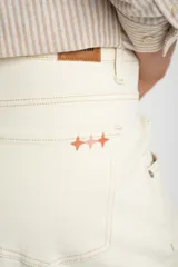 Pantalón tipo jean de corte wide leg y tiro medio, confeccionado en algodón peinado de color crudo.