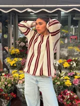 Sweater de tejido de punto de algodón con diseño rayado en color blanco, bordó y rosado, cuello redondo a la base, mangas largas acampanadas y silueta oversize.