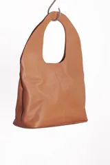 Bolso tote de cuero marrón oscuro, de gran tamaño y diseño minimalista, con asas integradas y costuras verticales visibles en el frente.