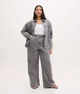 Pantalón de jean modelo wide leg color gris, con cintura tradicional, bolsillos funcionales y detalle de aplicaciones de brillos en la parte superior.