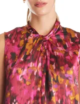 Blusa sin mangas de satén con estampado abstracto en tonos fucsia, rosa, naranja y negro. Presenta cuello alto con detalle de nudo frontal y cierre de botón en la espalda.