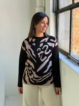 Sweater de tejido de punto con diseño estampado abstracto en tonos negro y beige, de cuello redondo y manga larga.