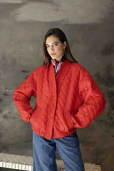 Campera acolchada de color azul marino, con diseño de rombos, cuello tipo chal y cierre frontal con botones grandes al tono. Presenta puños y ruedo acanalados, y bolsillos laterales.