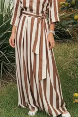 Falda larga de corte recto con diseño a rayas verticales en tonos marrón y blanco, con detalle de lazo ajustable en la cintura.